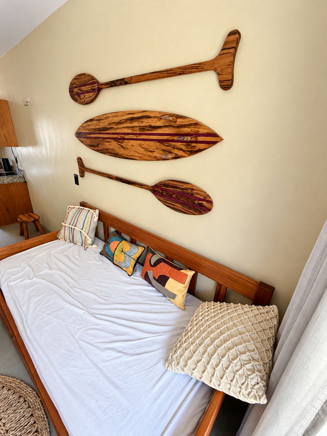 Un dormitorio con cama, almohadas y paneles de madera en la pared.