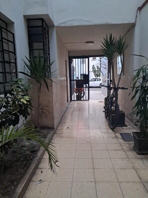 A corridor with tiled flooring, potted plants, a bicycle, and a motorcycle parked. - New Listing (Miraflores)