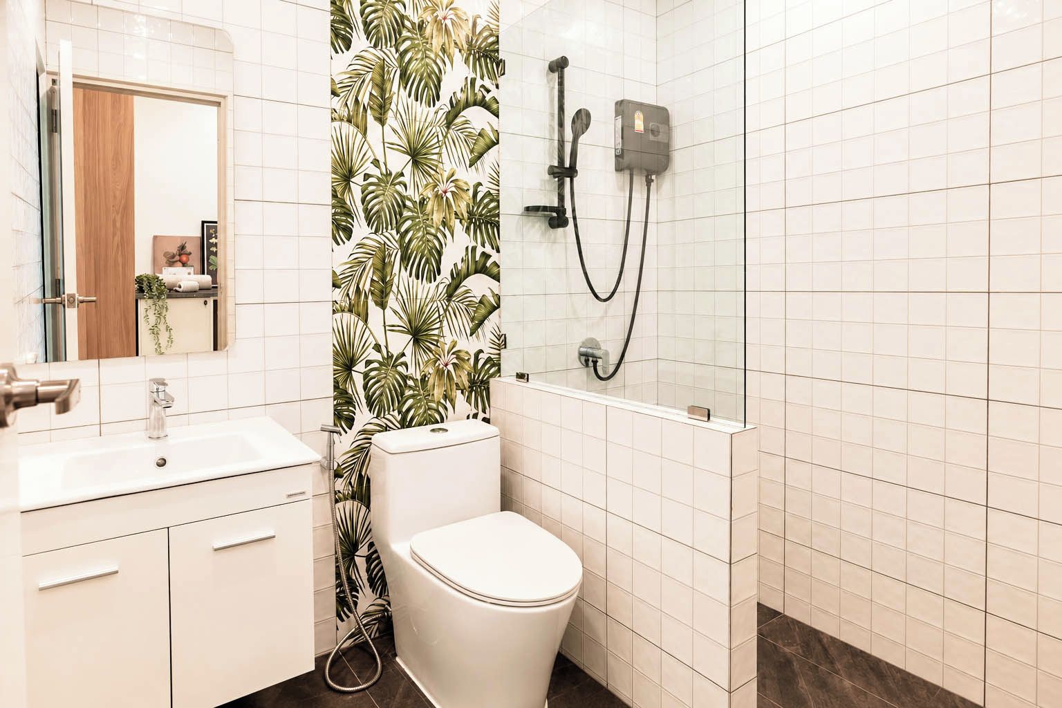 A bathroom with a toilet, sink, and shower area.