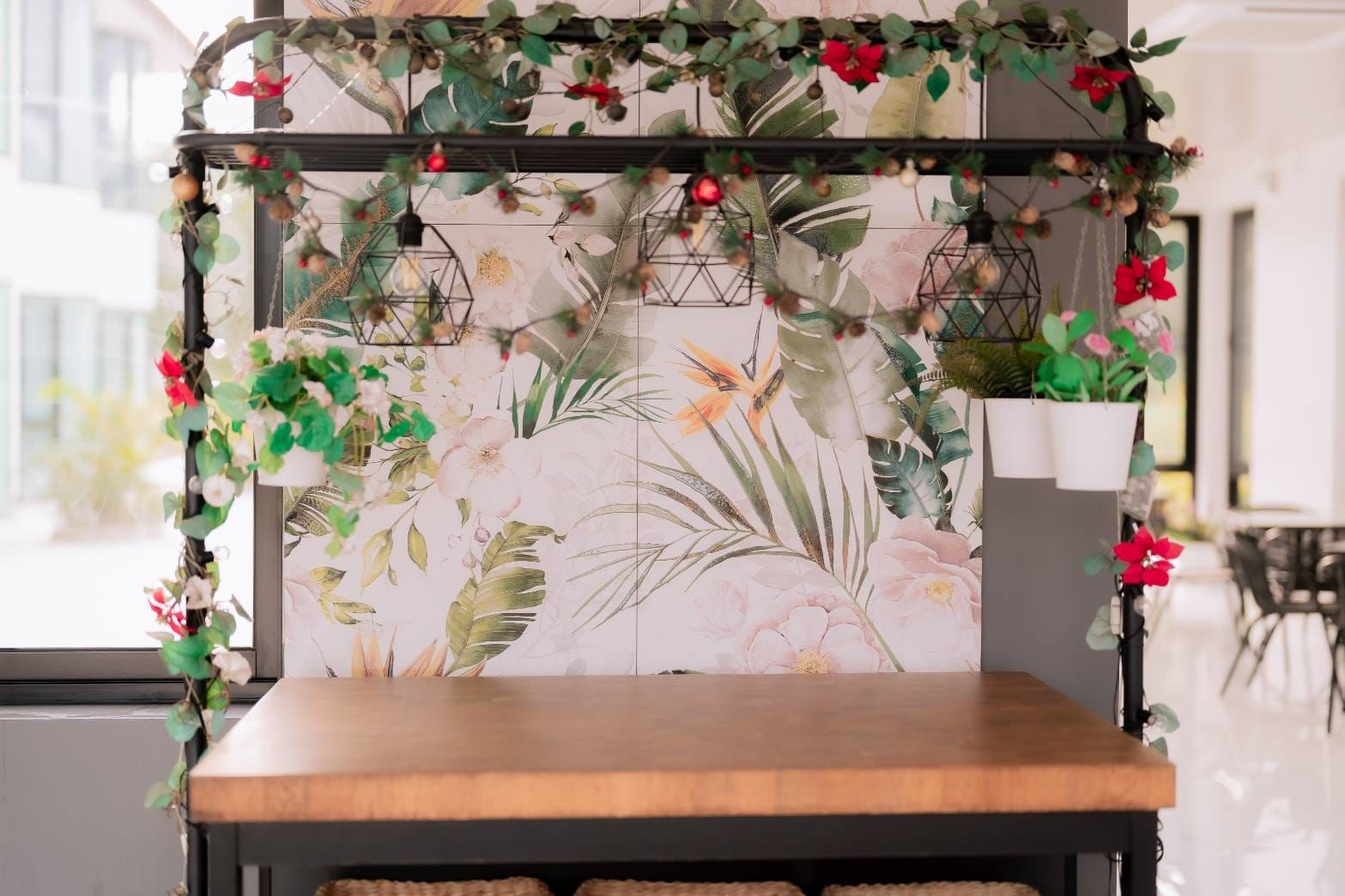 A wooden bench with a floral wallpaper backdrop, a hanging light fixture, and a potted plant.