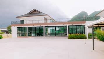 A modern building with a flat roof, large glass windows, and a balcony.