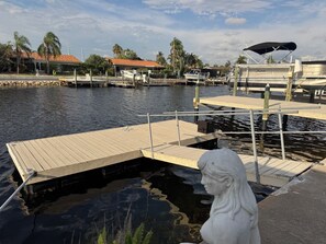 Uma marina com barcos, um cais e uma estátua.