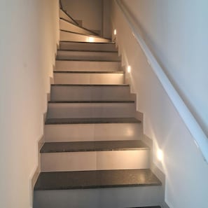 A staircase with a handrail and lighting on the steps. - New Listing (Itanhaém)