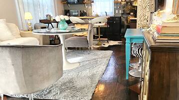 A living room with a sofa, a coffee table, a chandelier, and a patterned rug.