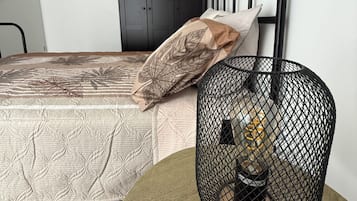 A bedroom with a bed, a wardrobe, and a round table with a decorative item.