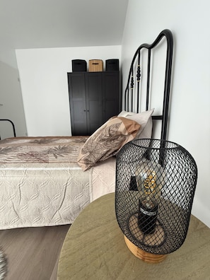 A bedroom with a bed, a wardrobe, and a round table with a decorative item.