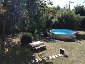 A backyard with a swimming pool, a wooden bench, and a small table. - New Listing (Romans-sur-Isère)