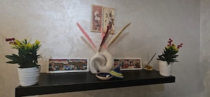 A shelf with two potted plants, a decorative vase, and two framed pictures. - New Listing (Arrahma)