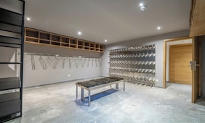 A modern interior with a bench, shelving units, and a patterned wall. - EXPERIENCE ALPINE LUXURY IN A SPACIOUS PENTHOUSE OVERLOOKING THE MATTERHORN (Zermatt)
