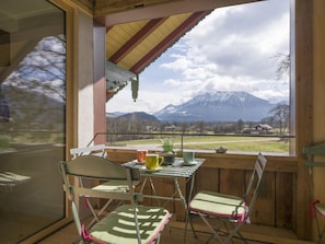 A balcony with a table and chairs, overlooking a mountainous landscape. - Holiday Apartment With 1 Bedroom (Oberaudorf)