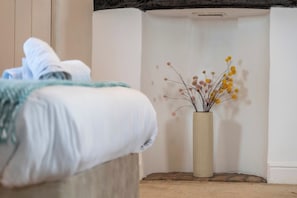 A bed with a white comforter and a beige vase with dried flowers. - Hot Tub & Games Room | Sleeps 11 | 4BR Wyboston (Wyboston)