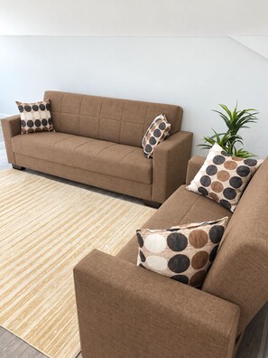 A living room with a brown sofa set, patterned cushions, and a striped area rug. - Serene 2-bedroom house with AC in Bodden Town (Bodden Town)