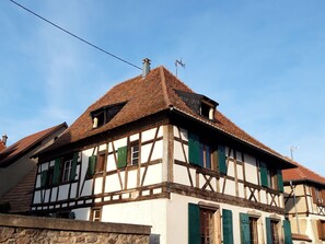 A traditional half-timbered house with a steeply pitched roof, multiple chimneys, and a visible power line. - New Listing (Dambach-la-Ville)