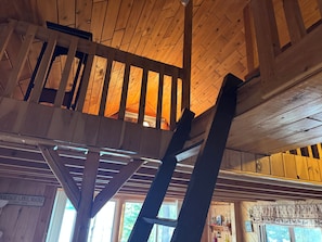 Ein Holzinnenraum mit einer Erschlafführungsfläche, einem Schild mit dem Ortsnamen Portage Lake, Maine, und einem Fenster mit Blick auf Bäume.