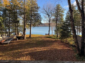 Ein Campingplatz am Seeufer mit einer Holzterrasse, einer Bank und Seeblick.