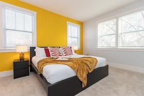 A bedroom with a bed, bedside tables, and windows. - Charlotte Retreat - Hot Tub, Games & Near Uptown (Charlotte)
