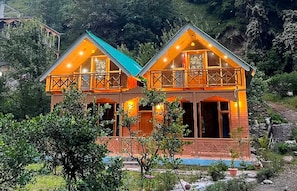 Una casa de dos pisos con un balcón y una piscina al frente.