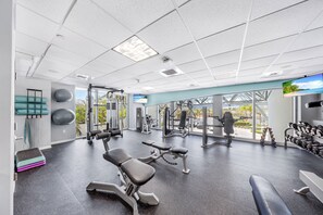 A gym with exercise equipment, a treadmill, and a large window with a view. - 26th floor 1-bedroom Condo with Washer and Dryer Sunny Isles Direct Beach Access (Sunny Isles Beach)