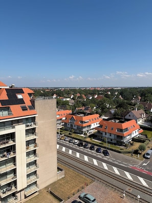 Een woongebied met moderne gebouwen, een weg met auto's en een spoorlijn.