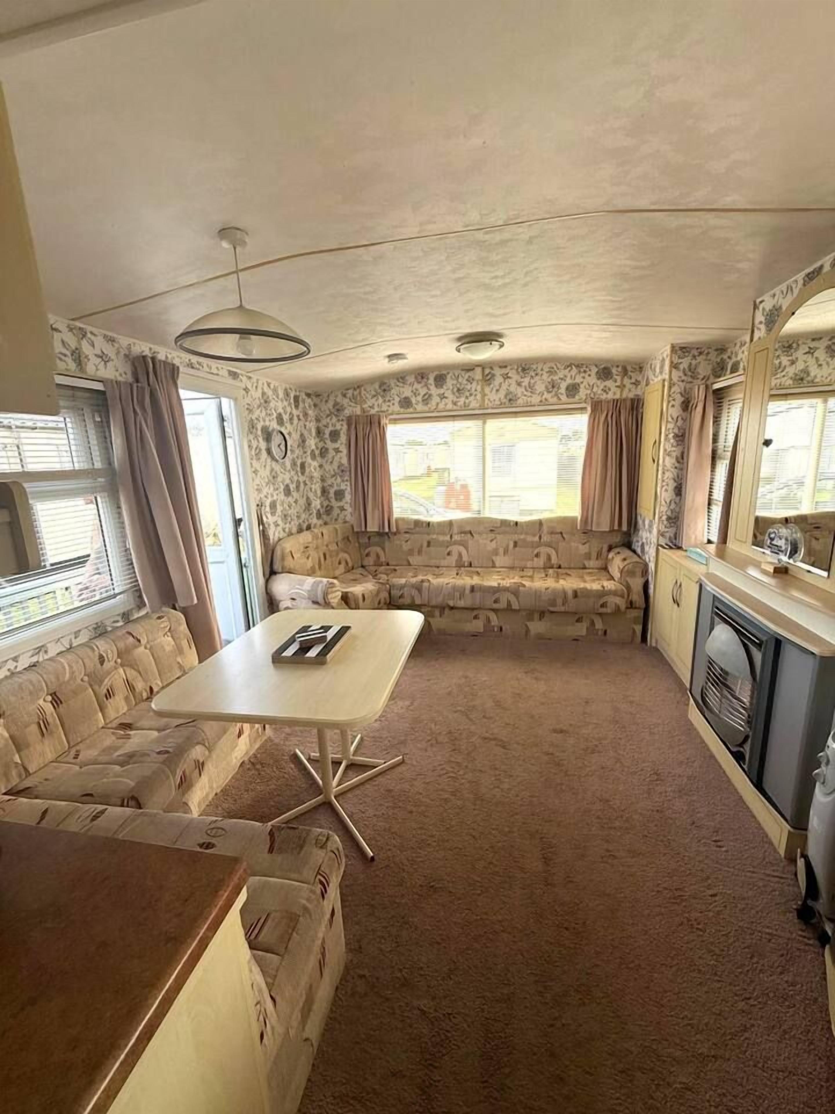 A compact living space with a sofa, a dining table, and a kitchenette area.