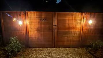 Una porta de fusta amb el número '1955' i dues làmpades murals.