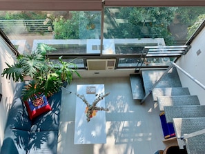 A modern room with a glass balcony, a sofa, a coffee table, and a staircase. - Smart Loft Home Office Laundry Parking (Santiago)