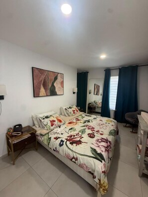 A bedroom with a bed, bedside tables, a desk, and a chair. - Wayaca 3br villa with private pool (Oranjestad)
