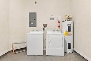 A laundry area with two front-loading washers and a stacked dryer. - Stylish Vista Cay 3br, Comfort at a Prime Location (Orlando)