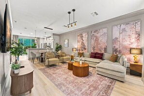 A modern living room with a sofa, armchairs, a coffee table, and a dining area. - Stylish Vista Cay 3br, Comfort at a Prime Location (Orlando)
