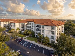 A multi-story residential building with a parking lot and a clear view of the surrounding area. - Comfortable 3BR Family Getaway, Top Location (Orlando)