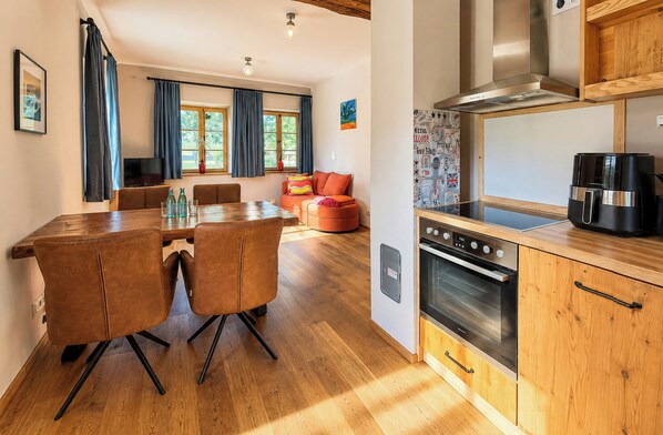 A modern kitchen with a built-in oven, a coffee machine, and wooden cabinets. - Apartment in the Countryside near Nature Reserve (Häuslingen)