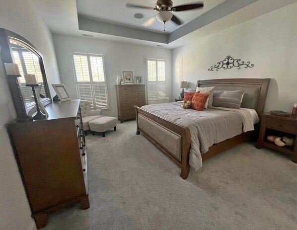 A bedroom with a bed, dresser, vanity, and a ceiling fan. - 2-bedroom apartment in peaceful The Plains with AC (The Plains)
