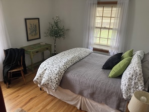 A bedroom with a bed, a nightstand, a chair, a table, and a window with blinds. - Two-story farmhouse on a working alfalfa farm, minutes from the wine district (Walla Walla)