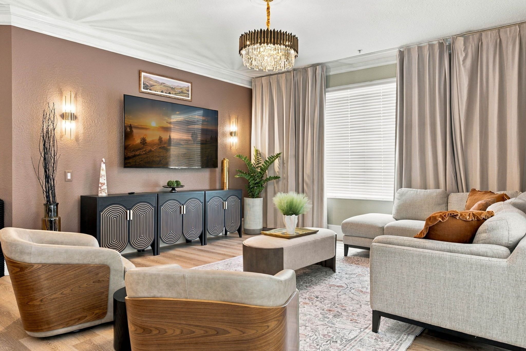 Un salon moderne comprenant un canapé, des fauteuils, une table basse, un téléviseur et une plante décorative.