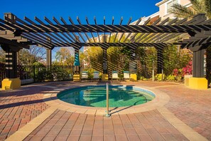 A circular pool with a pergola overhead, surrounded by a brick patio and a fence. - Spacious 3BR Near Parks and Convention Center (Orlando)