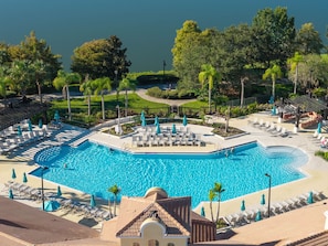 A resort with a large swimming pool, sun loungers, and a view of the surrounding landscape. - Spacious 3BR Near Parks and Convention Center (Orlando)