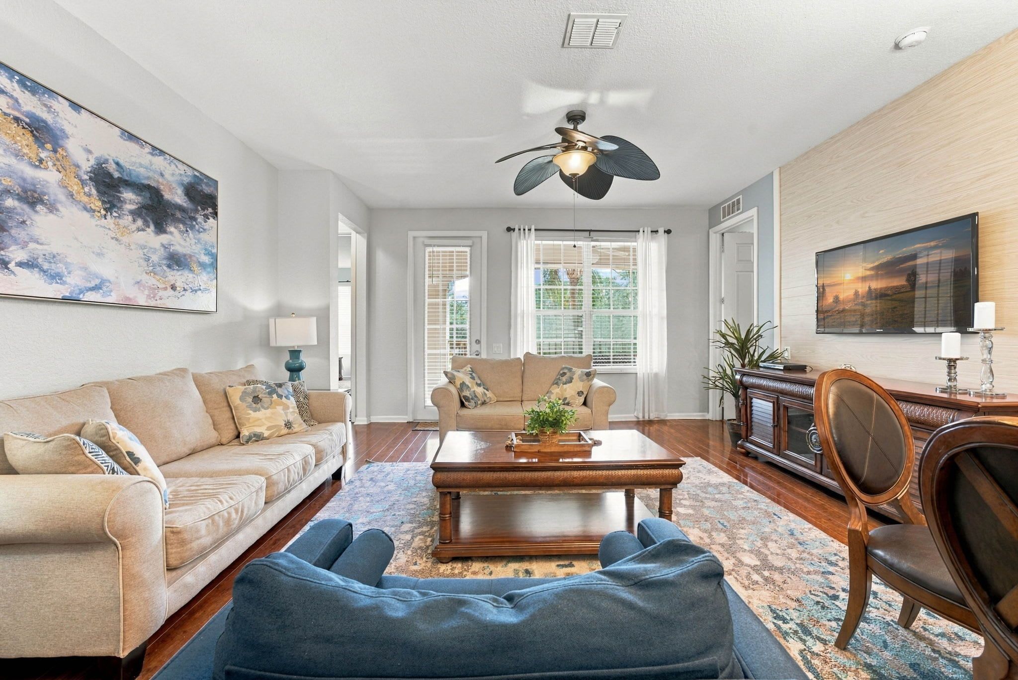 A living room with a sofa, a coffee table, and a blue bean bag.