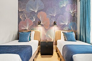 A hotel room with two beds, a nightstand, and a wall with a leaf pattern. - Stylish Vista Cay 3BR Comfort at a Prime Location (Orlando)