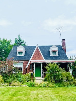 A two-story house with a green door, a chimney, and a satellite dish. - Charming Vintage renovated 2 story Cape Cod home near Boardman Shopping (Youngstown)