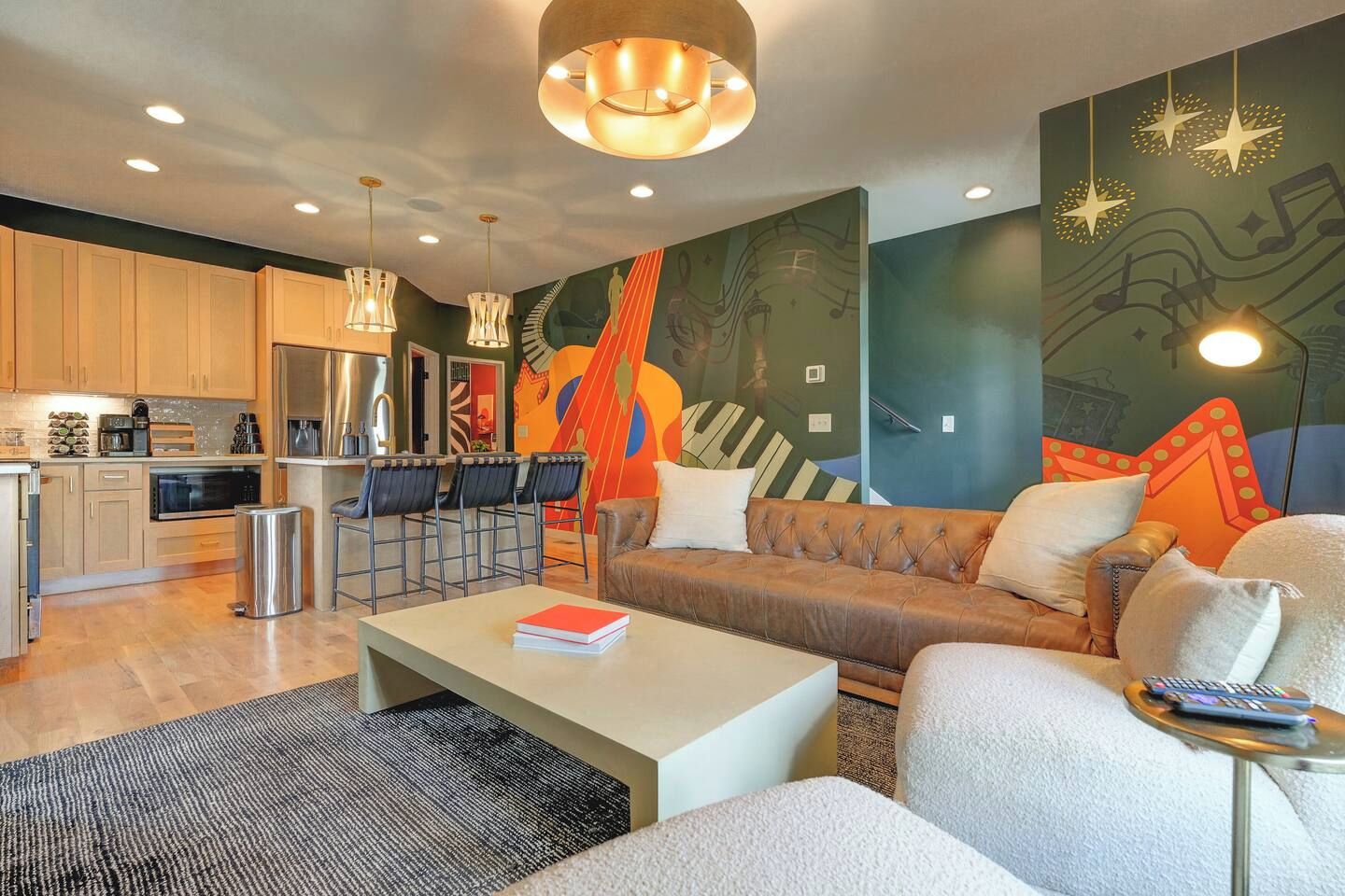 A modern living room with a sofa, coffee table, and a kitchen area with a refrigerator and microwave.