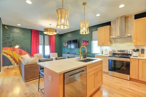 A modern kitchen with a central island, wooden cabinets, and stainless steel appliances. - Off Broadway Nashville: Rooftop Hot Tub & Skyline Views (Nashville)