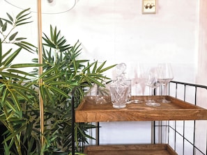 A wooden tray with a decanter and glasses on a metal railing, surrounded by green foliage. - Artist's 1 Bed Apartment in Westminster / Central London (London)