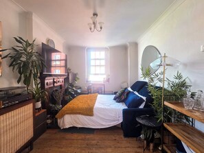 Un dormitorio acogedor con cama, escritorio y diversas plantas.