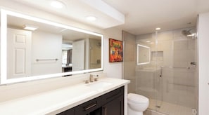 A modern bathroom with a large mirror, a shower enclosure, and a toilet. - Cozy 1-bedroom deluxe condo located on the strip of Las Vegas (Las Vegas)