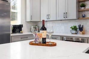 A kitchen counter with a wine bottle, two glasses, and a thank you card. - Charlotte Retreat - Hot Tub, Fire Pit & Uptown (Charlotte)