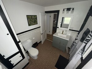 A bathroom with a toilet, sink, and mirror. - Stay Awhile • King Bed • Pet Friendly • 2BR (Elyria)