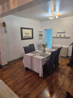 A dining area with a table set for four, a ceiling fan, and a blue door in the background. - Welcome to Your Stylish East London Getaway!
Newly renovated from top to bottom (Barking)
