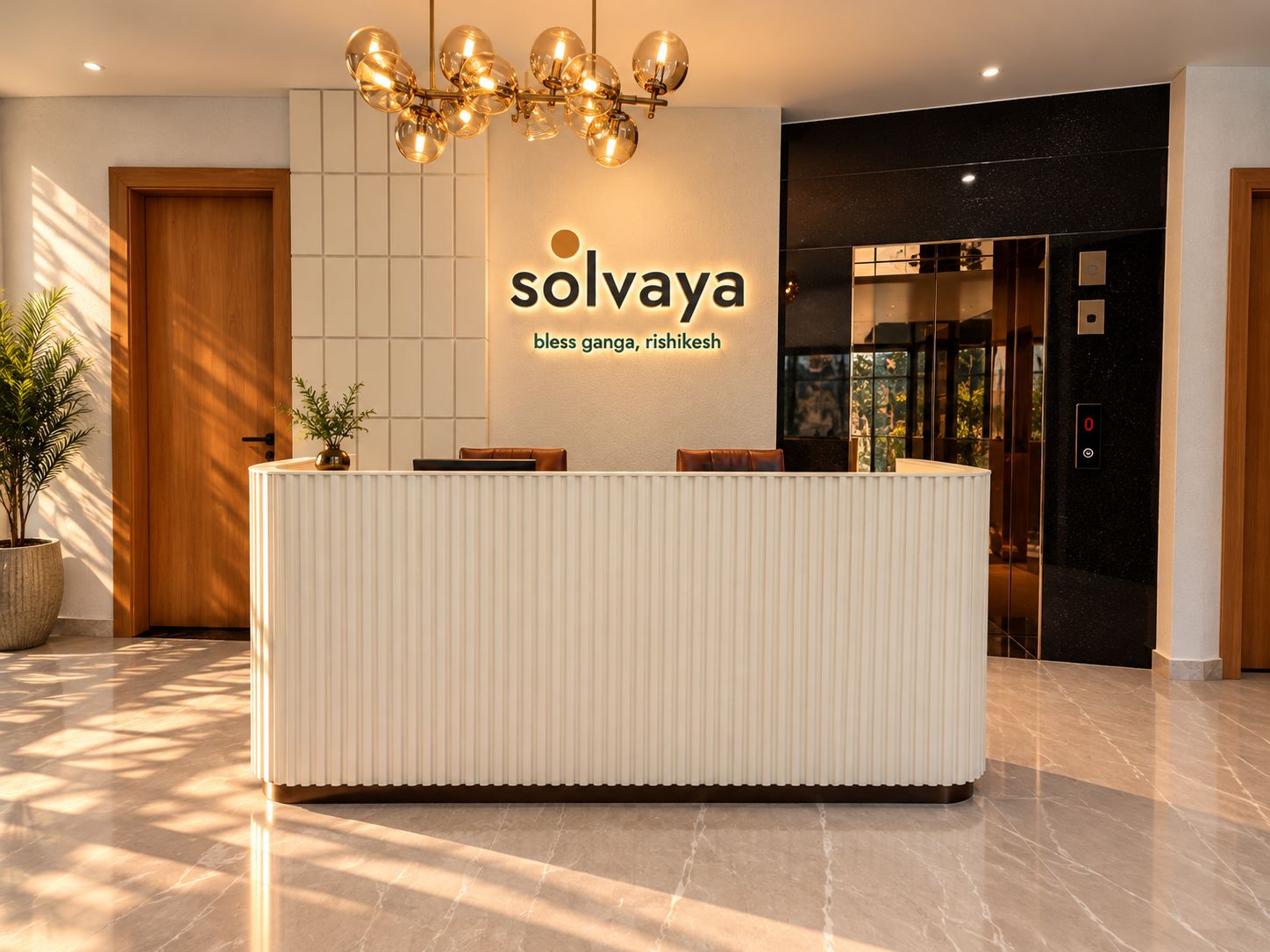 A reception desk with a modern design, a chandelier, and a sign that reads 'solvaya bless gangha, rishikesh'.