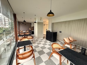 A hotel room with checkered flooring, wooden chairs, a reception desk, and pendant lighting. - Bless Ganga by Solvaya Rishikesh (Rishikesh)