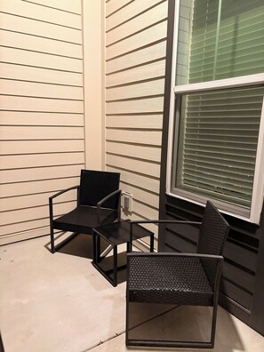 A corner seating area with two chairs and a small table against a house exterior. - Elevated Luxury apartment in Downtown Jacksonville (Jacksonville)